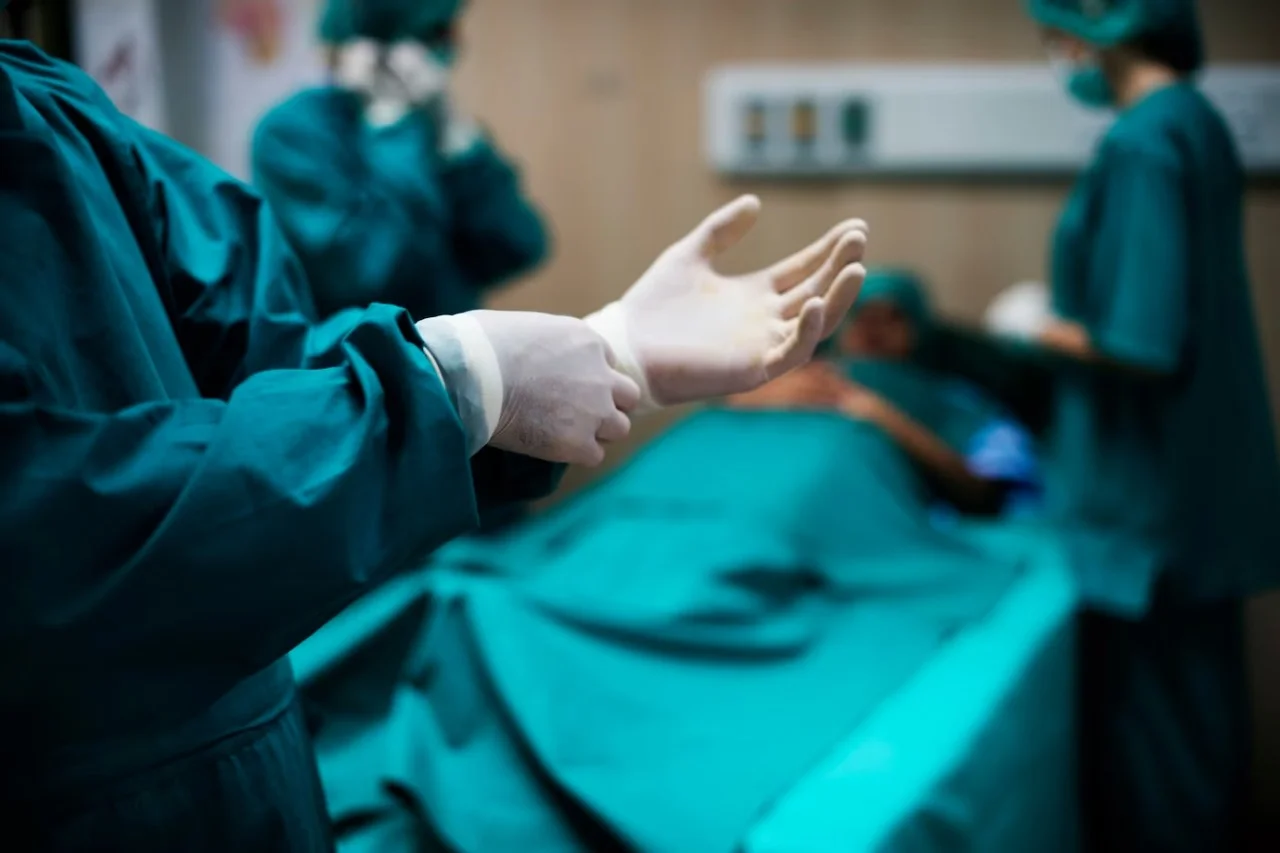 a person wearing surgical gloves and gloves